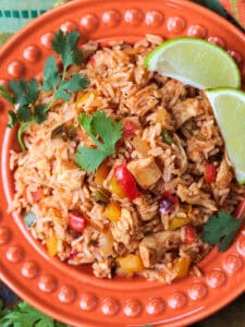 chicken fajita rice on plate with limes and cilantro