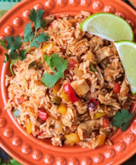 chicken fajita rice on plate with limes and cilantro
