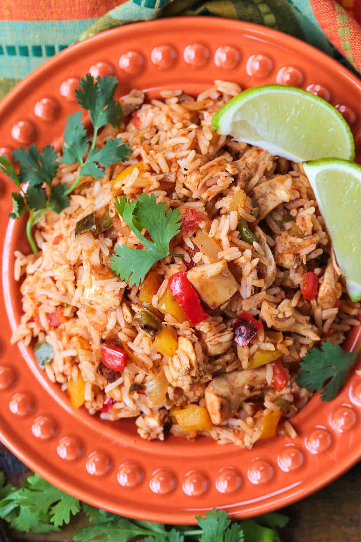 Chicken Fajita Rice is packed with charred vegetables, tender chicken and seasoned rice. Ideal for busy nights, ready in less than 30 minutes! chicken fajita rice on plate with limes and cilantro