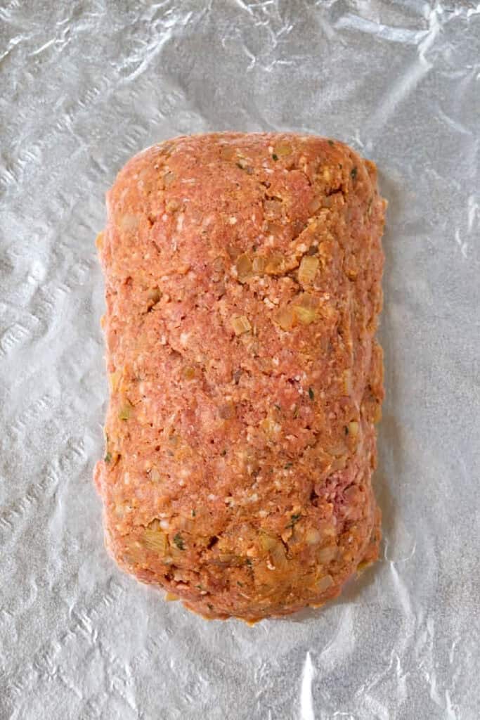 uncooked meatloaf in a loaf shape on foil