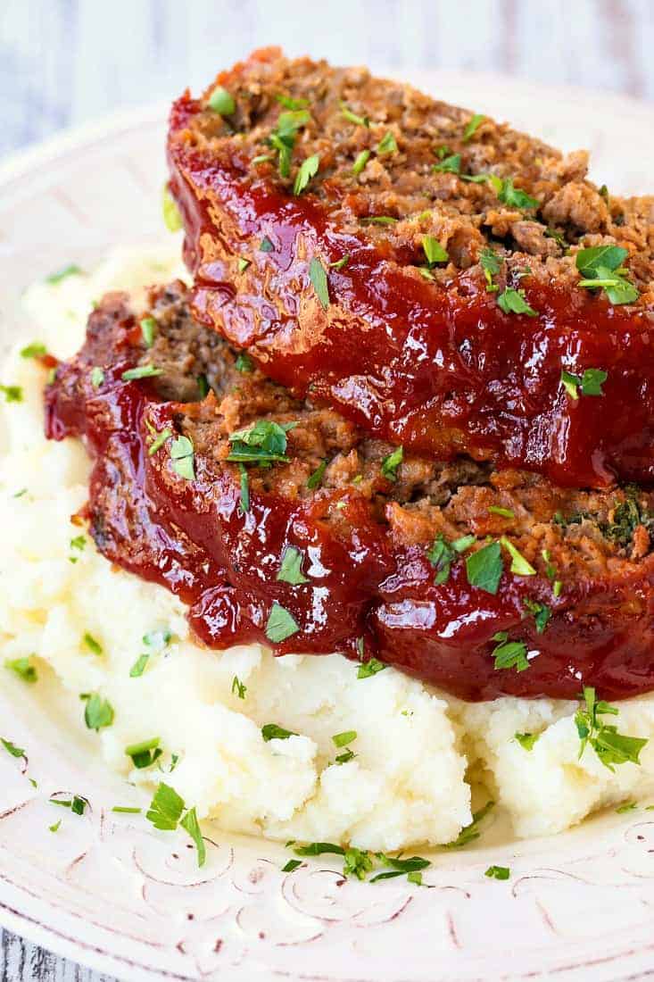 This Classic Meatloaf Recipe with ketchup glaze brings me back to my childhood! Tender, flavorful meatloaf recipe with a tomato glaze! Classic Meatloaf Recipe is made with beef, pork and veal and topped with a brown sugar and ketchup glaze