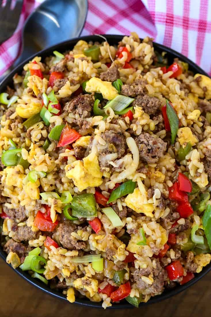 fried rice with ground beef, peppers and cheese in a bowl