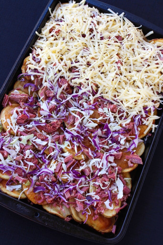 Irish Nachos with Corned Beef are perfect for St. Patrick's Day! Thin, crispy potatoes topped with corned beef and tons of cheddar cheese. layers of cheese, cabbage and corned beef on fried potato chips