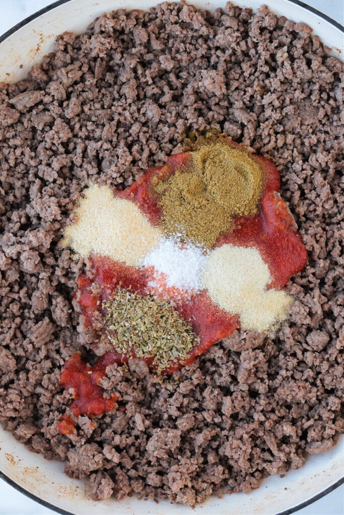 Make taco night even better with our homemade Ground Beef Taco Meat! 15 minutes is all you need to have the most delicious, homemade tacos! ground beef in skillet with tomato sauce and seasonings