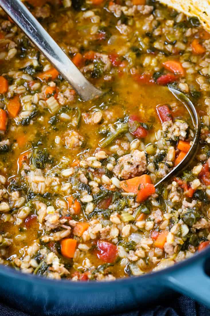 sausage soup with spinach and farro in pot