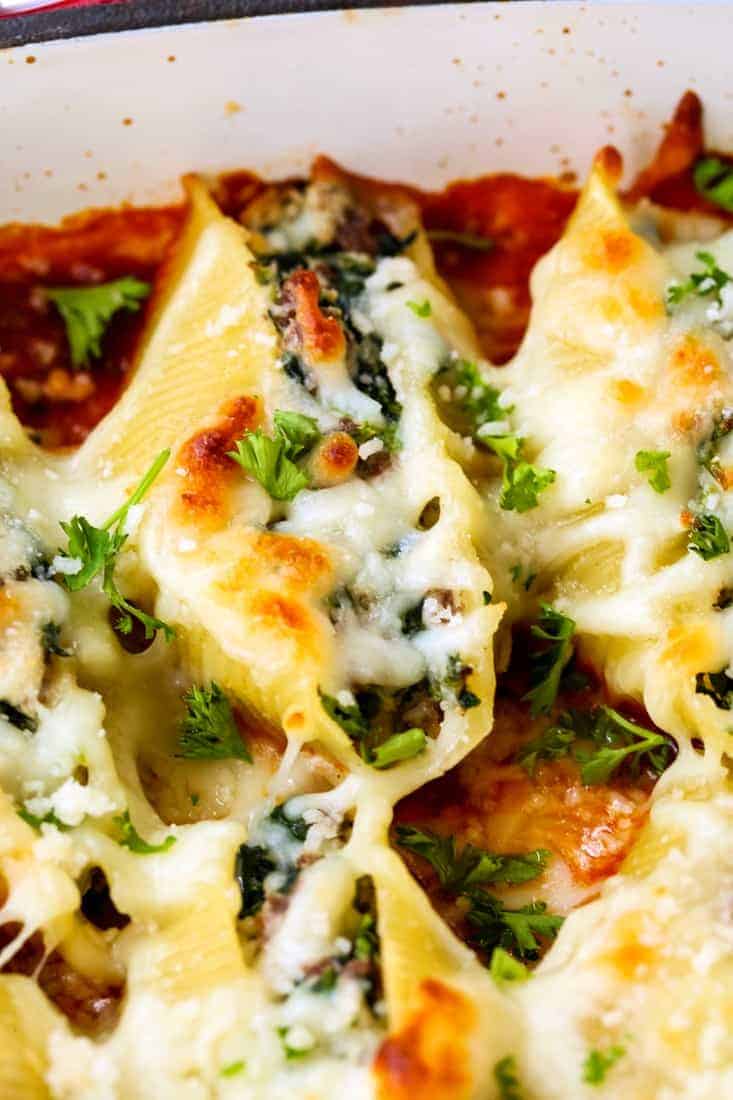 Stuffed shells covered in melty golden-brown cheese and garnished with parsley.