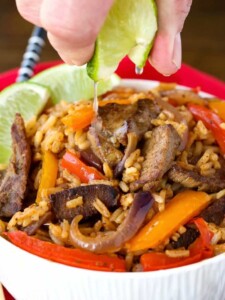 Steak Fajita Fried Rice in a bowl with a lime squeeze