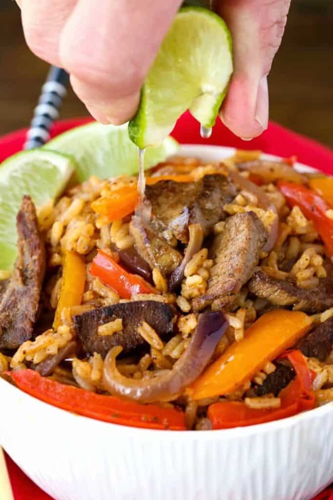 Steak Fajita Fried Rice in a bowl with a lime squeeze