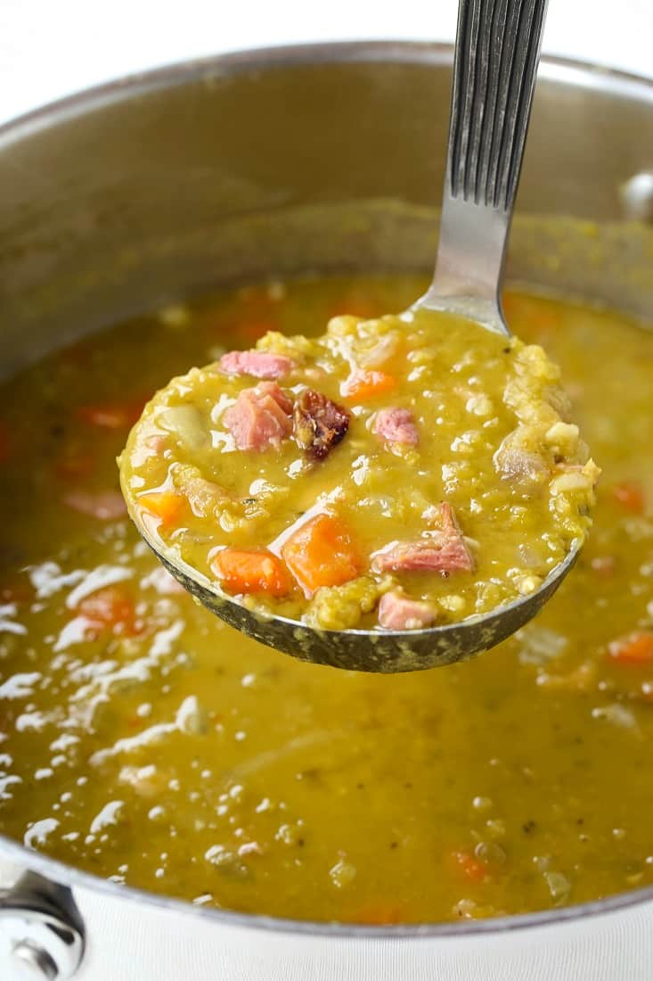 Split pea soup in a ladle with ham and carrots