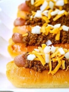 Chili dogs with hot dogs stacked on a platter