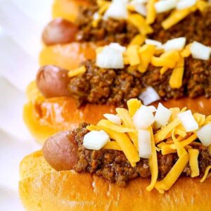 Chili dogs with hot dogs stacked on a platter