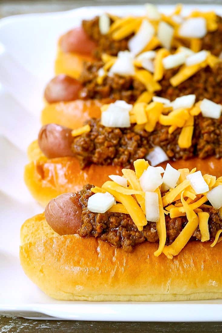 Chili dogs with hot dogs stacked on a platter