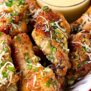 Crispy Garlic Parmesan Chicken Wings on a white plate with dipping sauce