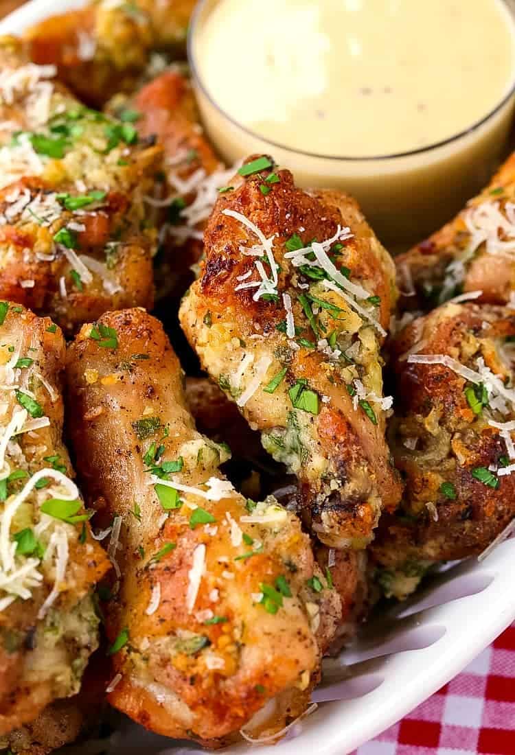 Crispy Garlic Parmesan Chicken Wings on a white plate with dipping sauce