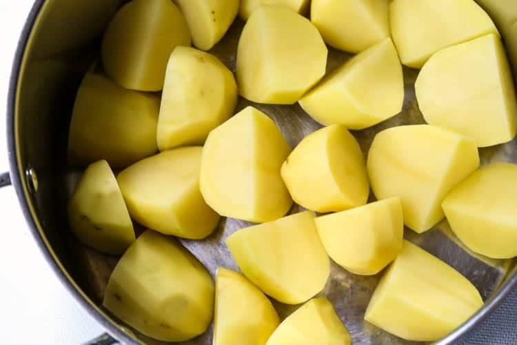 Classic Potato Salad starts by boiling cubed potatoes in a pot of water