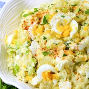 potato Salad with chopped eggs in a white bowl with napkin