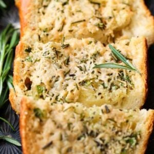 Rosemary Asiago Garlic Bread sliced on a sheet pan