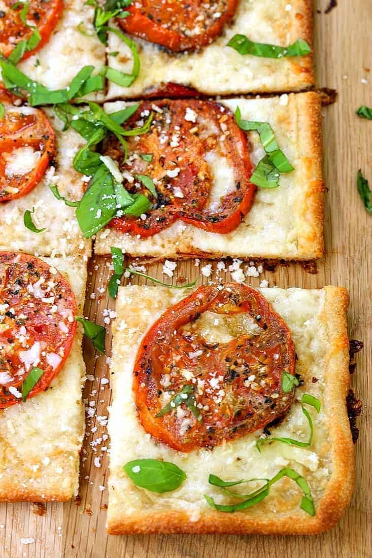 Roasted Tomato Basil Pizza sliced into squares on a cutting board