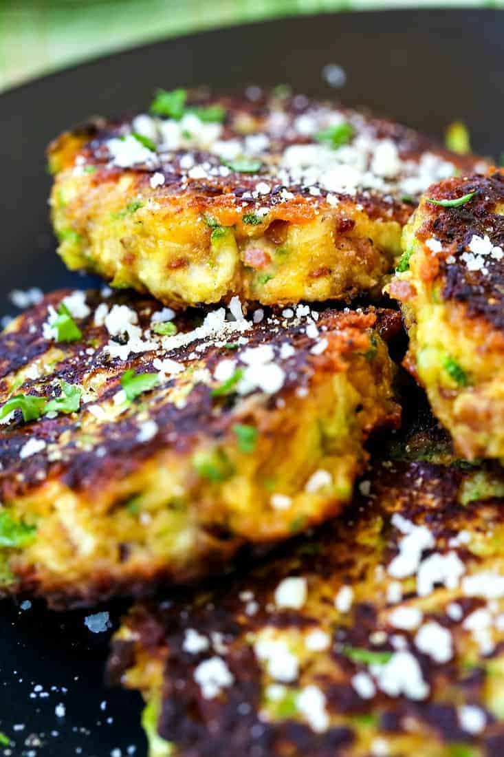 zucchini cakes with bacon and cheese topped with grated parmesan cheese