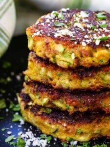 bacon zucchini cakes stacked on a black plate