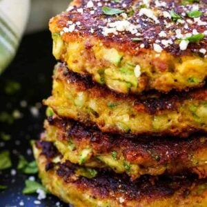 bacon zucchini cakes stacked on a black plate
