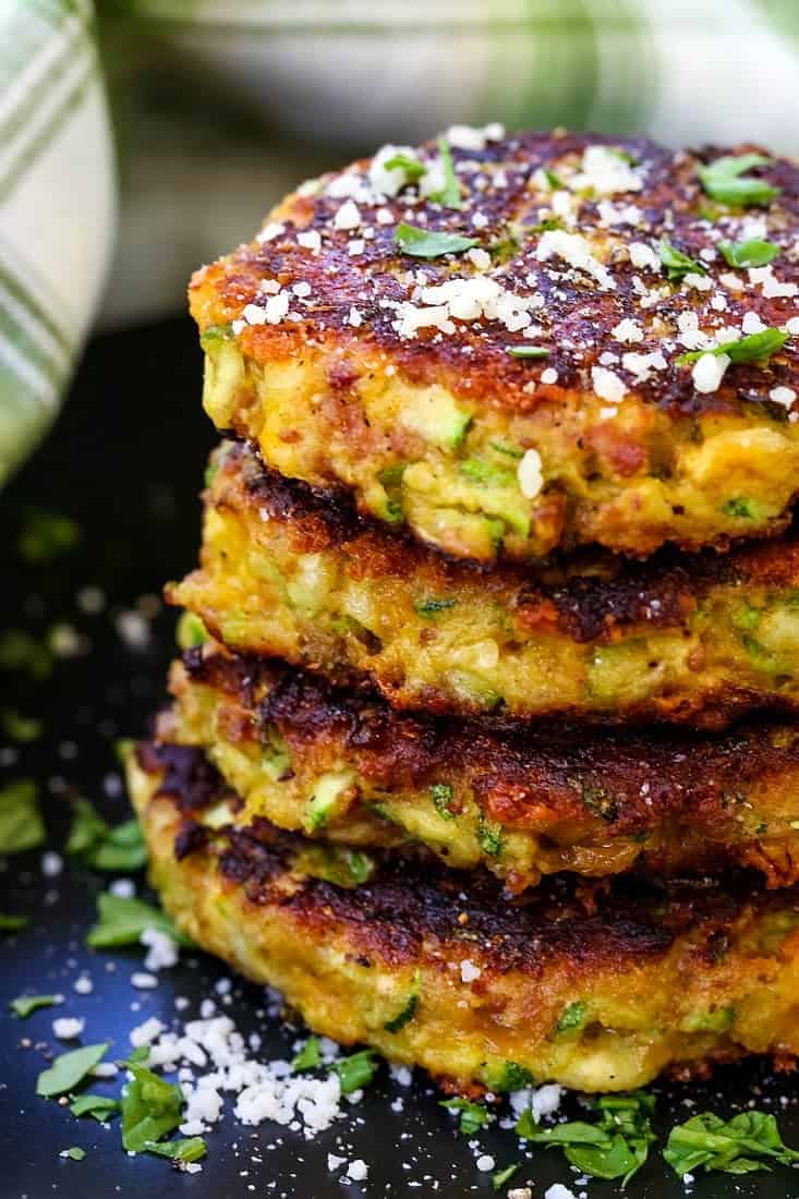 bacon zucchini cakes stacked on a black plate