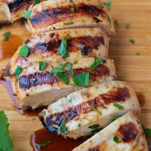 sliced grilled chicken breast on a board