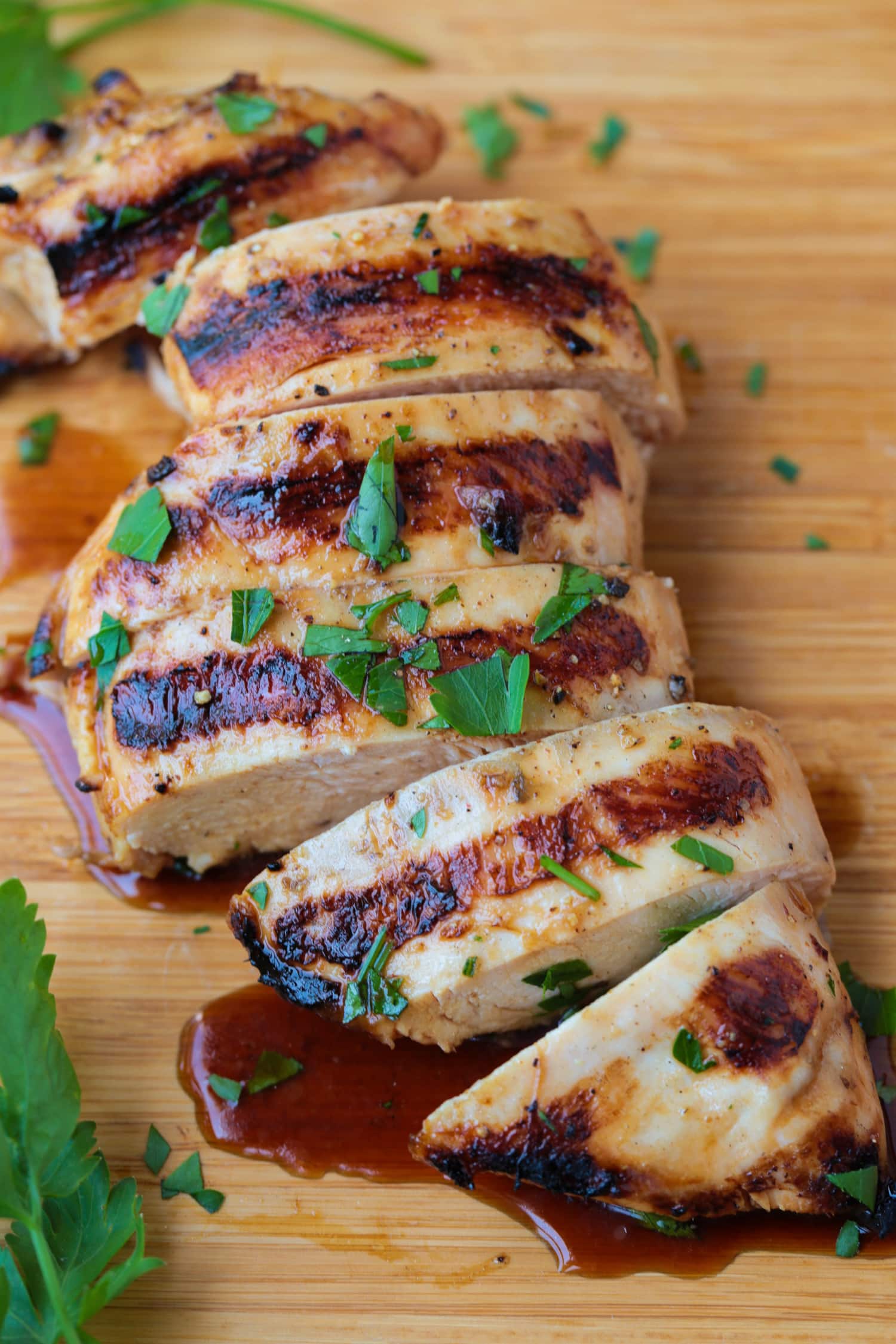 sliced grilled chicken breast on a board