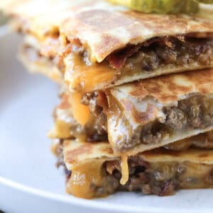 quesadillas stacked on a plate with pickles on top