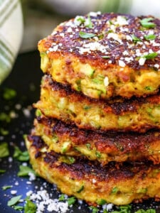 zucchini cakes stacked on black plate