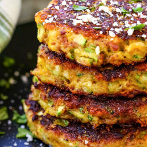 zucchini cakes stacked on black plate