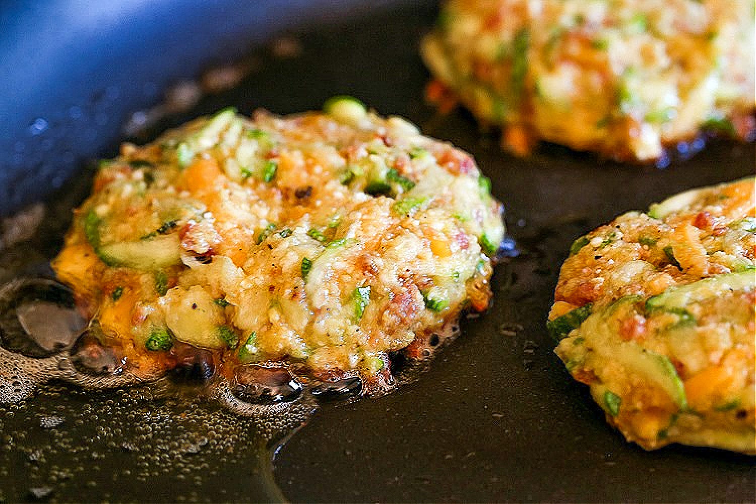 raw zucchini cakes in skillet