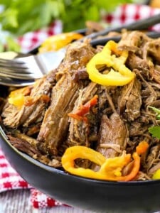 Slow cooker italian beef that's shredded in a black bowl