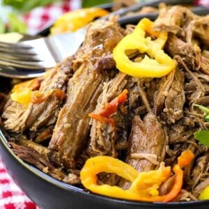 Slow cooker italian beef that's shredded in a black bowl