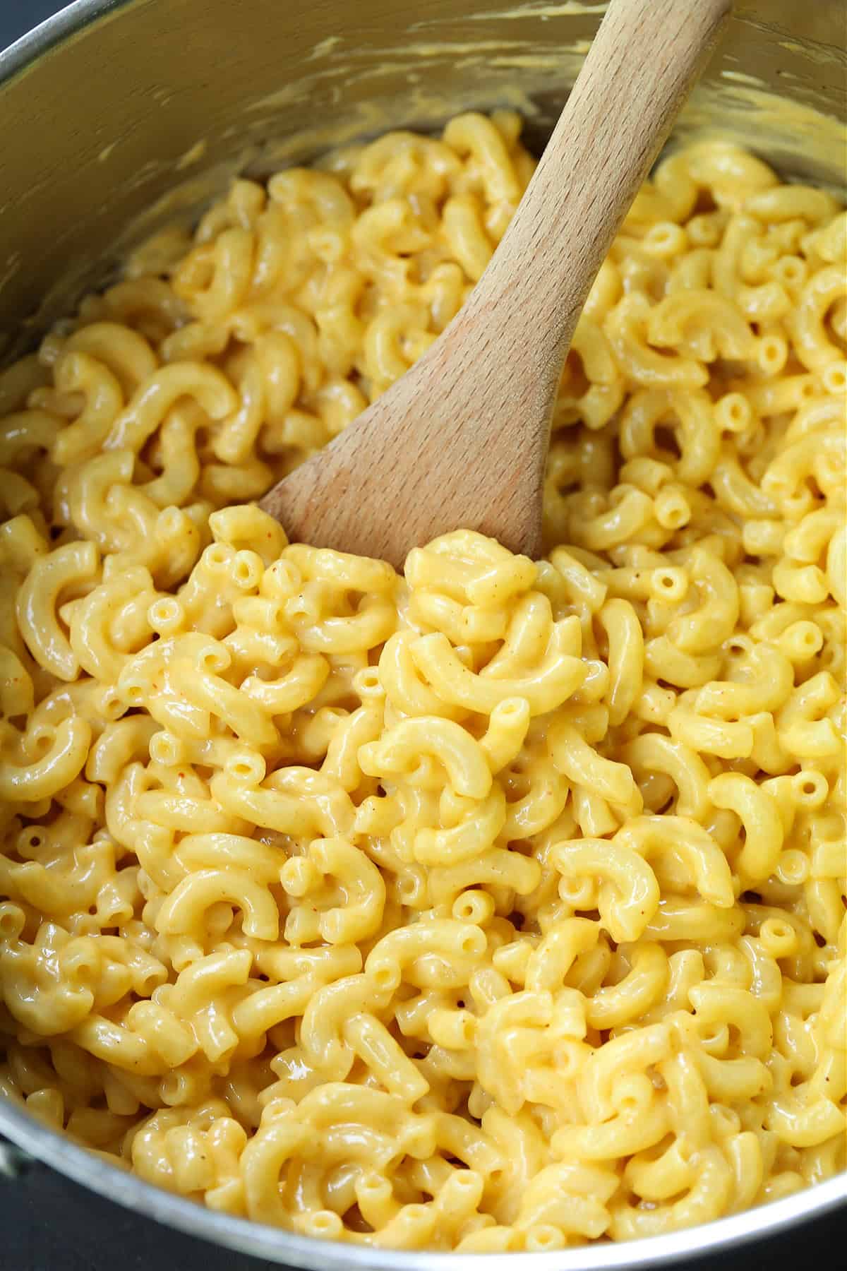This 15-minute stovetop mac and cheese is creamy, cheesy, and packed with flavor! Skip the box and make this one-pot mac and cheese instead! pot with wooden spoon in macaroni and cheese