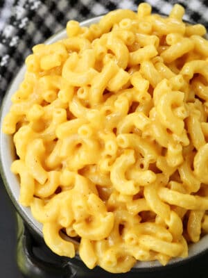 black bowl of macaroni and cheese with checkered napkin