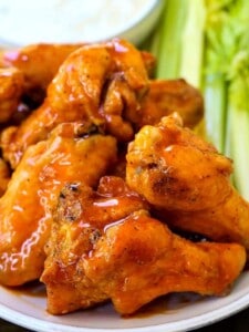 baked buffalo chicken wings stacked on a platter