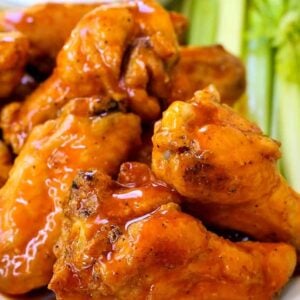 baked buffalo chicken wings stacked on a platter