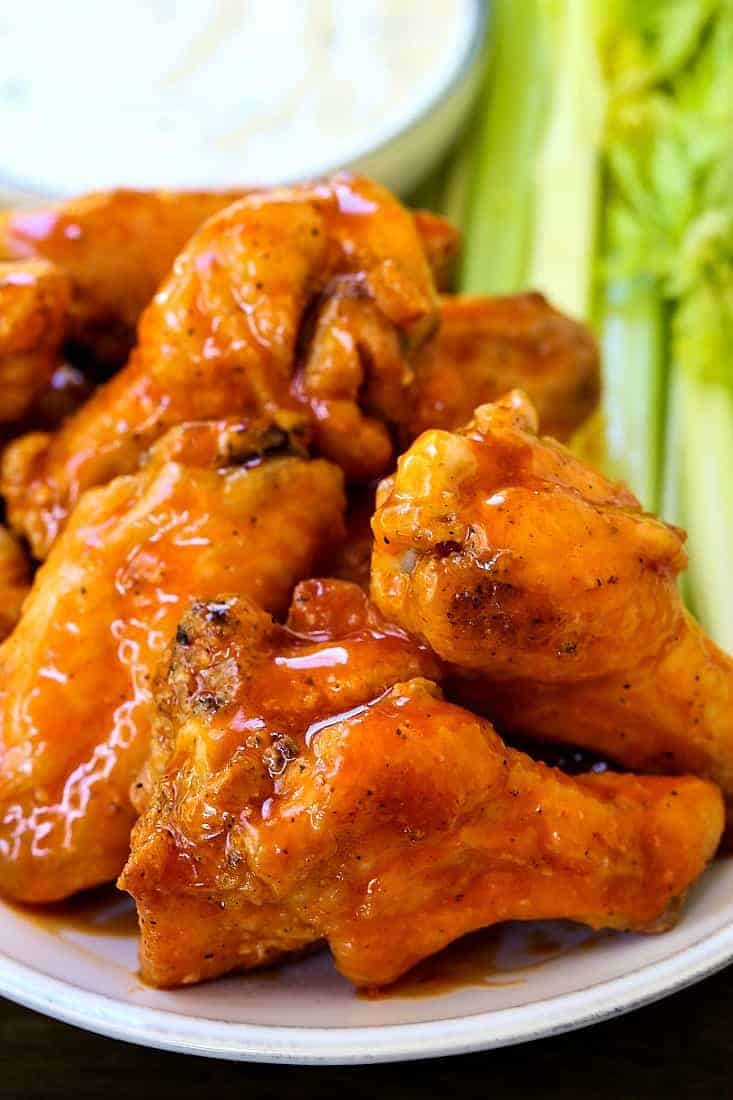 baked buffalo chicken wings stacked on a platter