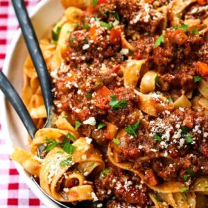 bolognese sauce in a white bowl with forks