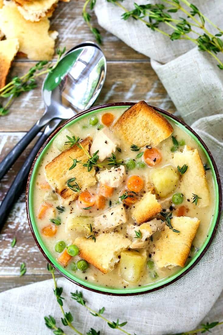 chicken pot pie soup with spoons on a wooden board