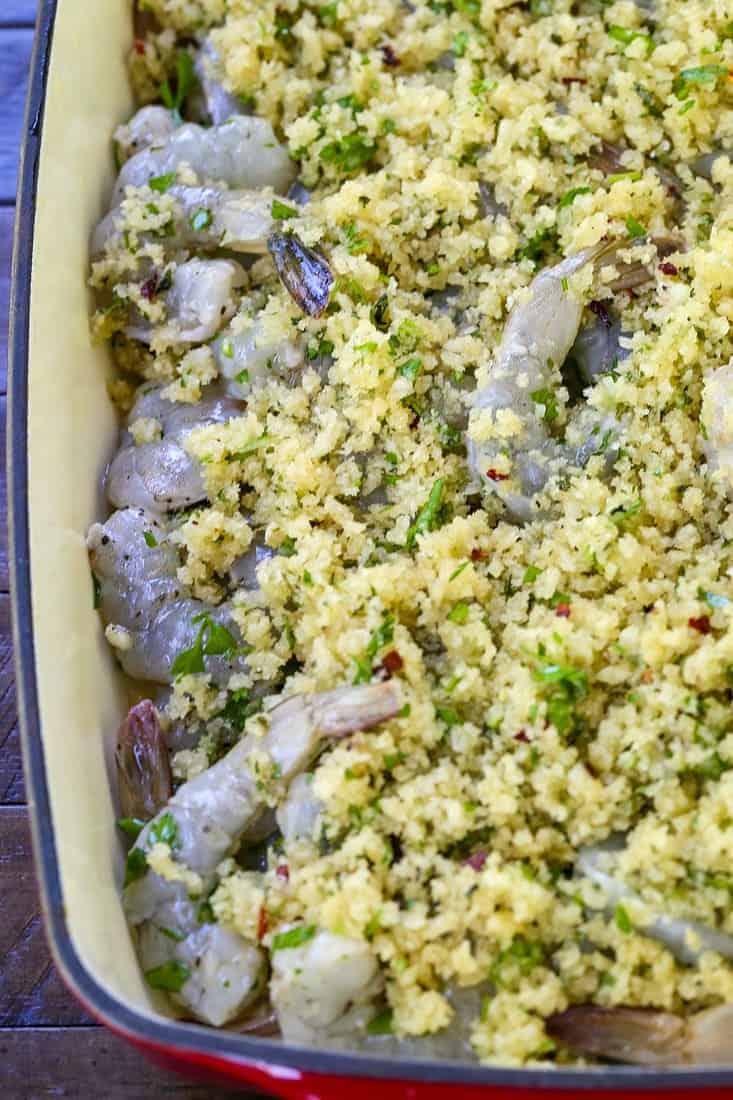 shrimp in a baking dish with buttery breadcrumbs before cooking