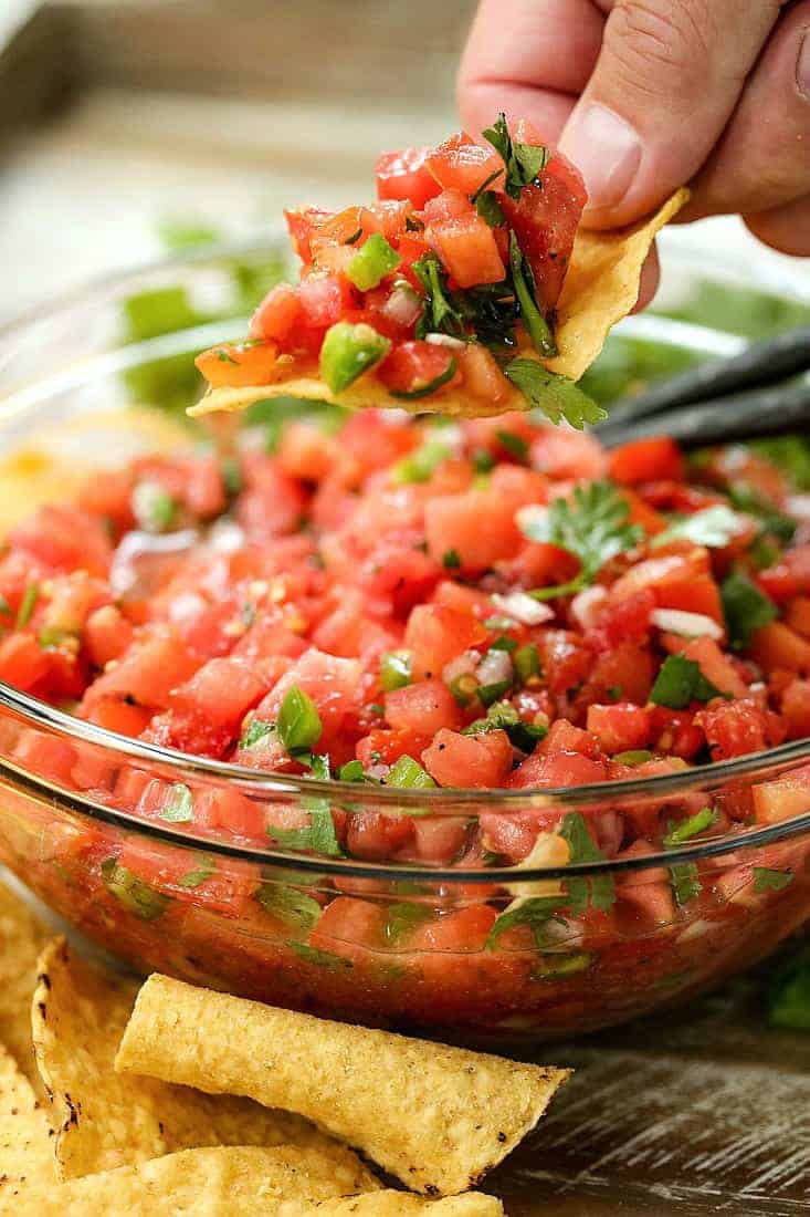 pico de gallo recipe in a bowl with chips on the side