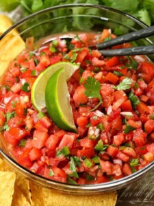 fresh pico de gallo in a bowl with limes