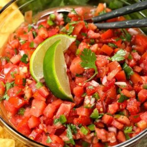 fresh pico de gallo in a bowl with limes