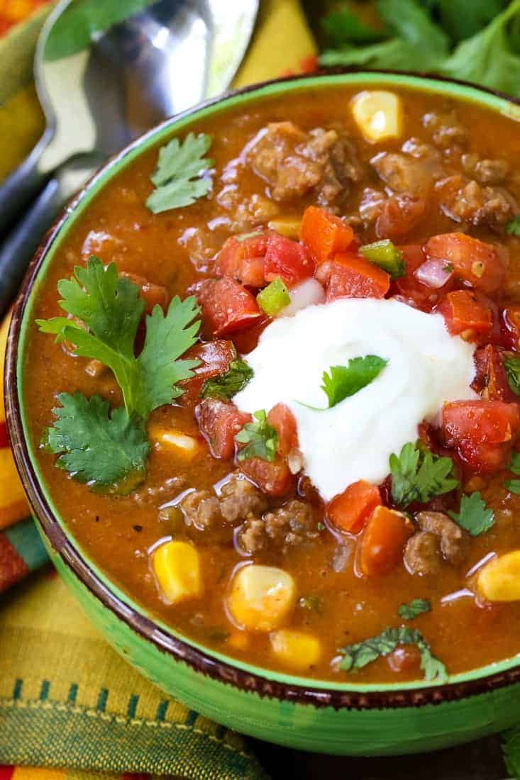 taco soup recipe in a bowl with cream cheese and cilantro