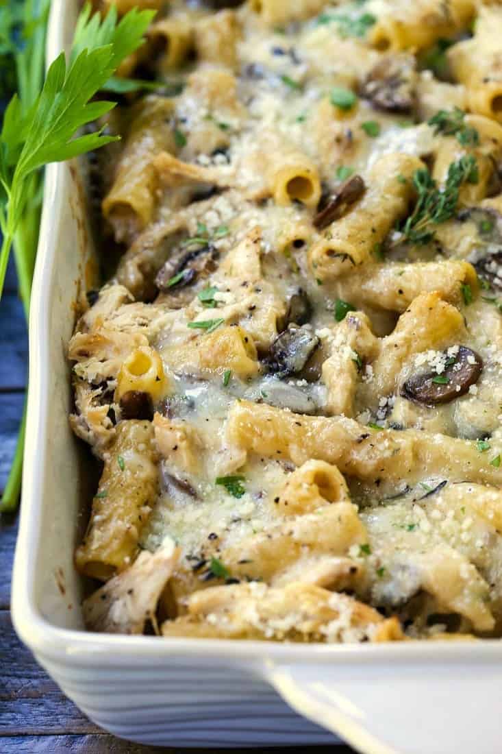 baked ziti with mushrooms and chicken in a white casserole dish