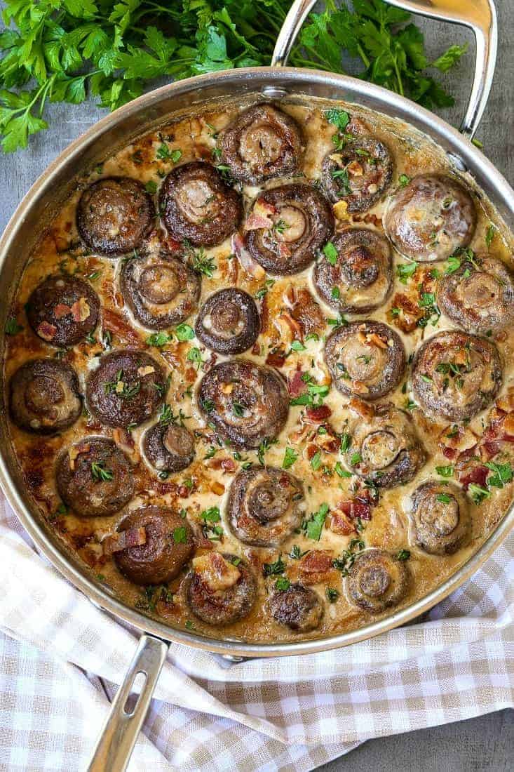 Our Creamy Bacon Mushrooms are cooked in the most addicting cream sauce! Spoon over steak or chicken, even makes an amazing pasta sauce! Creamy bacon mushrooms in a skillet with parsley
