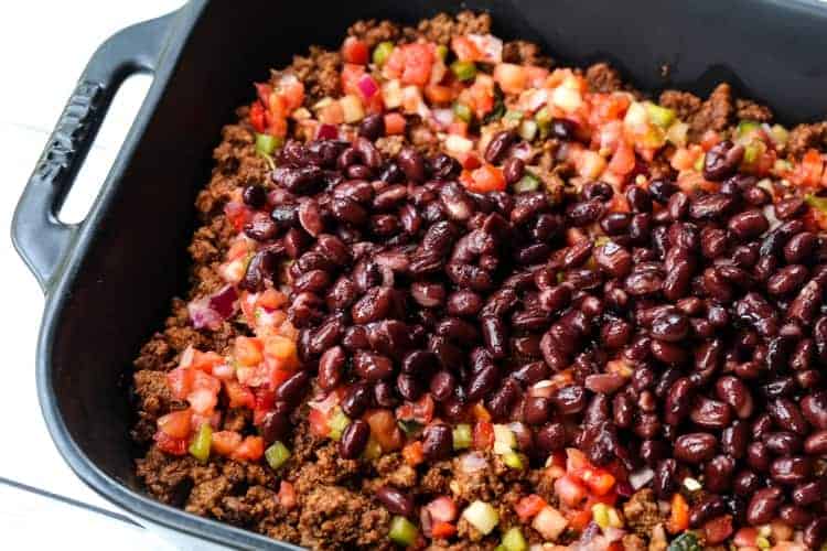 This Taco Casserole Recipe brings the party to dinner time! Loaded with seasoned ground beef, beans and cheese, your friends and family are going to come running to the dinner table! taco casserole with beef, beans and fresh salsa