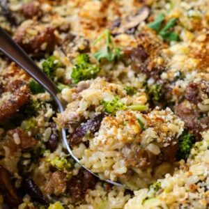 spoon of sausage and broccoli casserole in dish